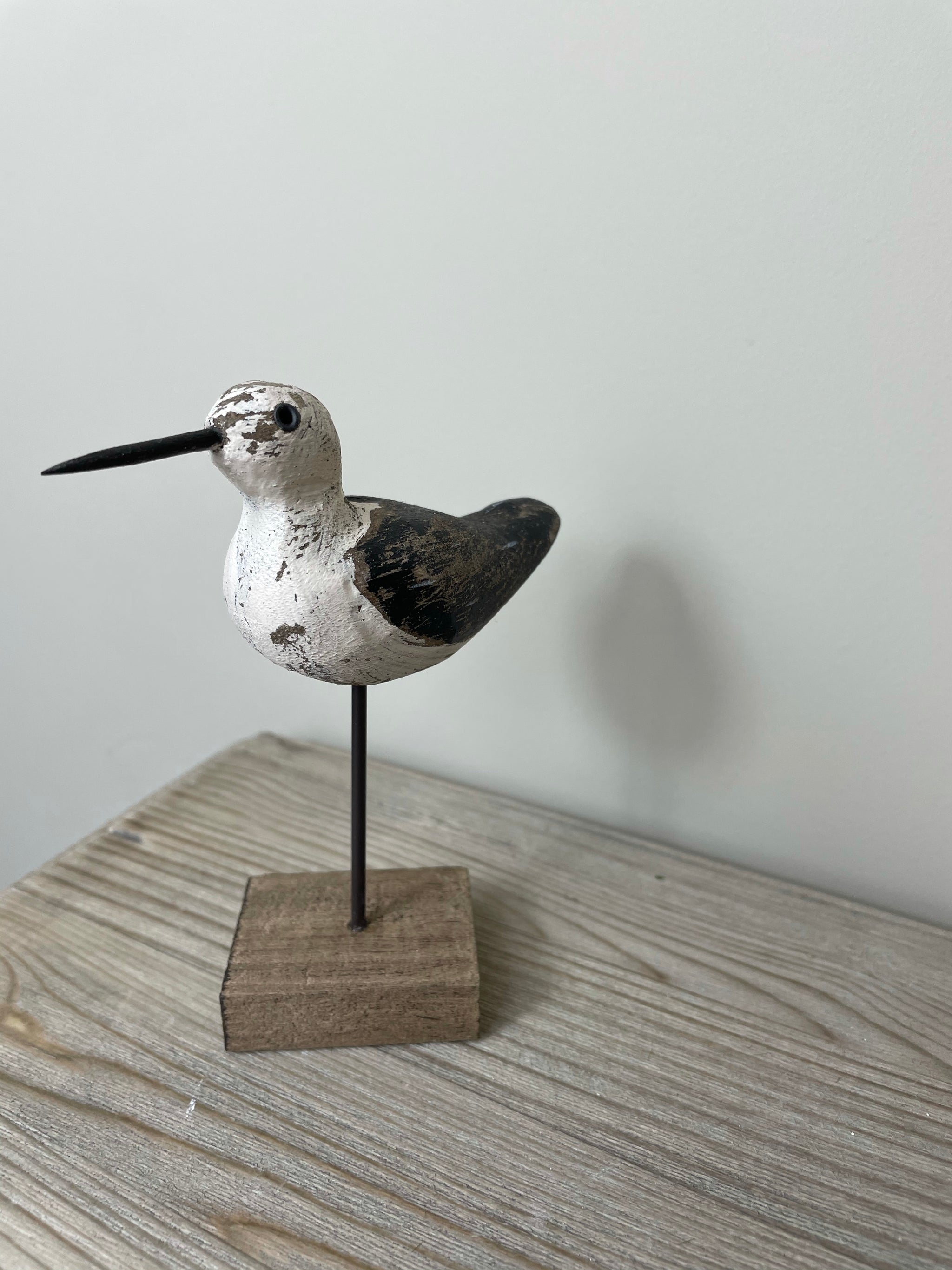 Small sandpiper on wooden base